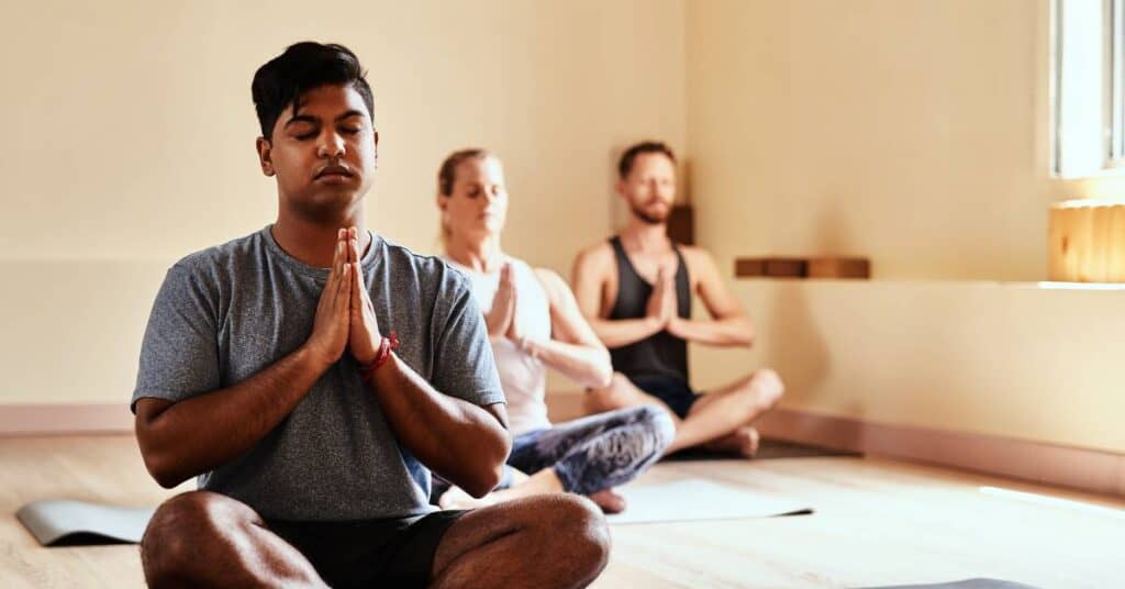 techniki medytacyjne 3 osoby na matach w trakcie medytacji