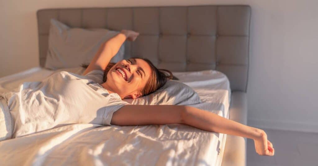 cyfrowy detoks wyspana kobieta przeciąga się w łóżku