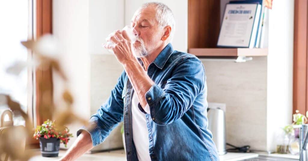 picie wody jako forma detoksu starszy mężczyzna pije wodę