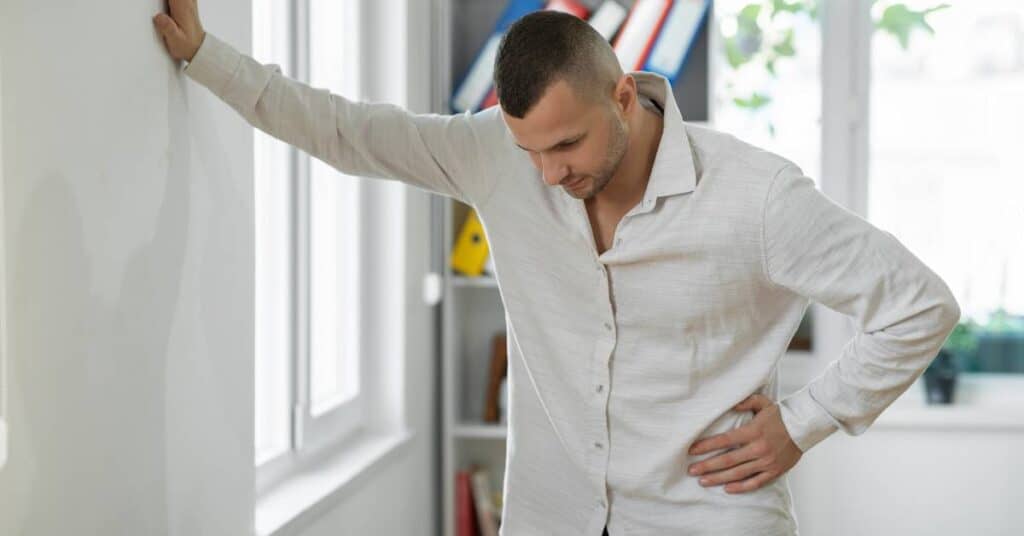 post buchingera jako forma detoksu zawroty głowy mężczyzna podpiera się o ścianę