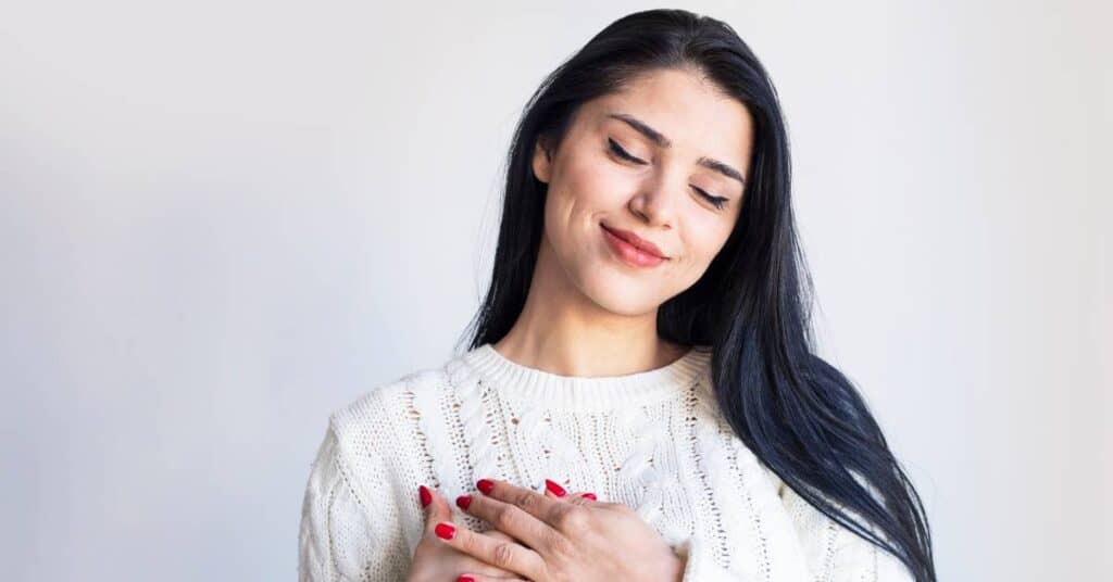 psychoterapia zadowolona kobieta trzymająca ręce na sercu